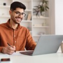 Portrait,Of,Young,Smiling,Arab,Man,In,Glasses,Using,Laptop
